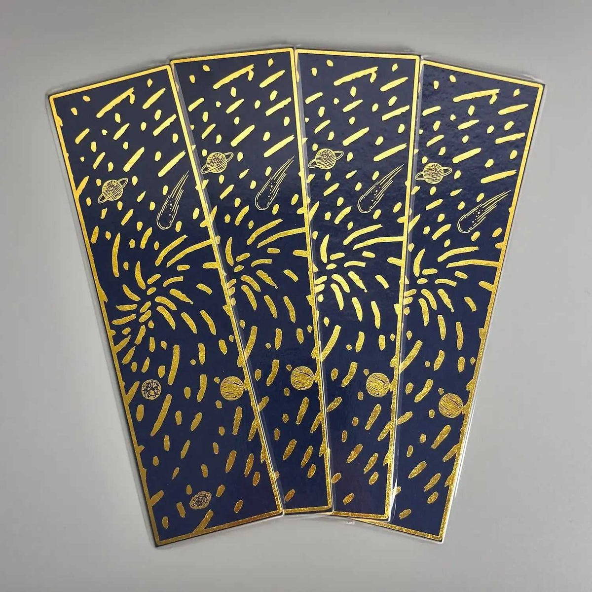 Navy blue bookmarks with gold foil planets, comets, and stars, cosmic design for readers