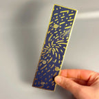 Blue bookmark with gold celestial design, featuring planets and stars