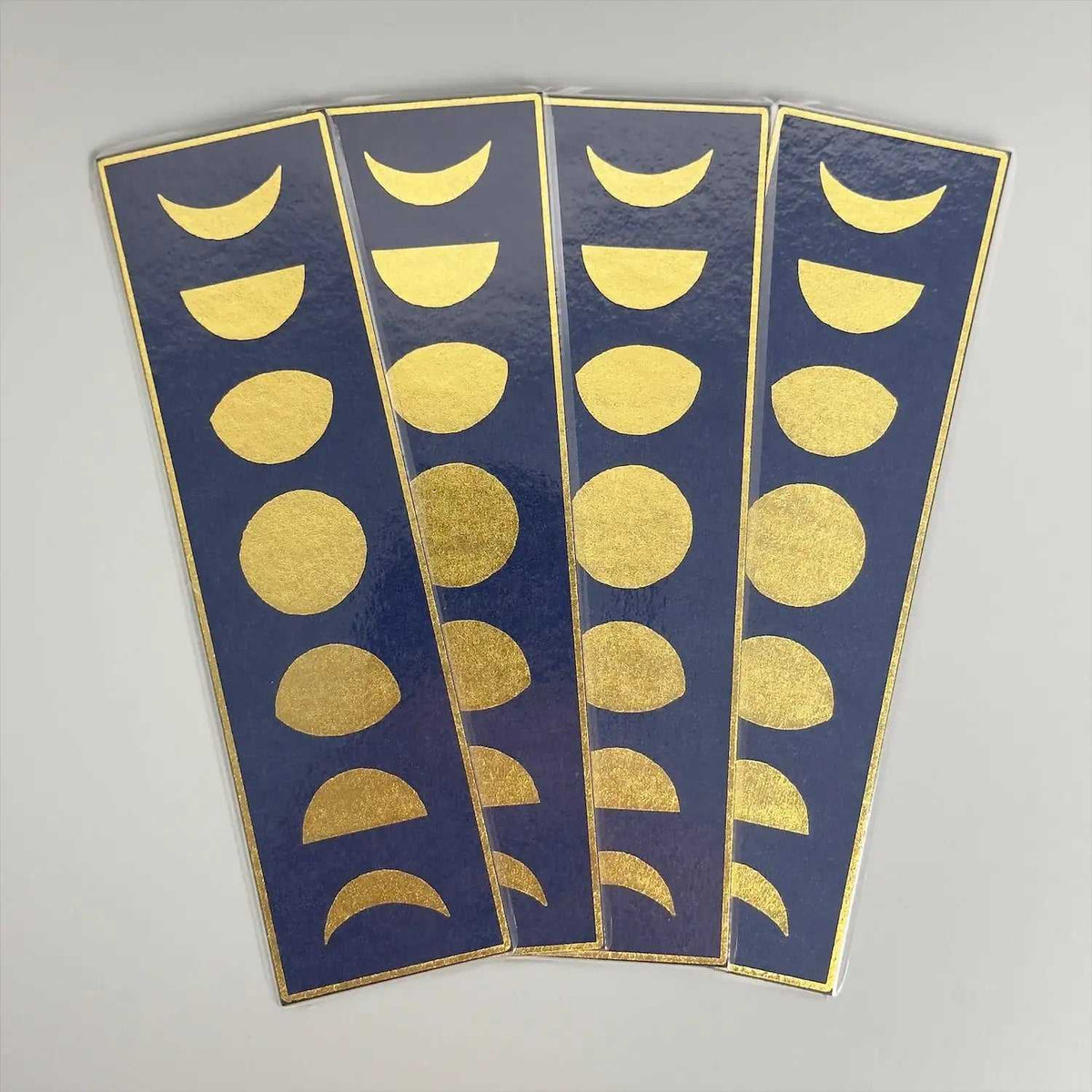 Gold moon phase stickers on navy blue, celestial-themed decorative labels for journals or planners